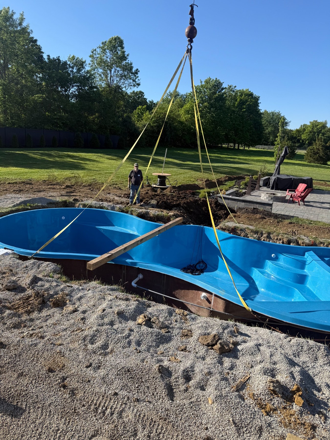 In-ground pool shell being placed by crane