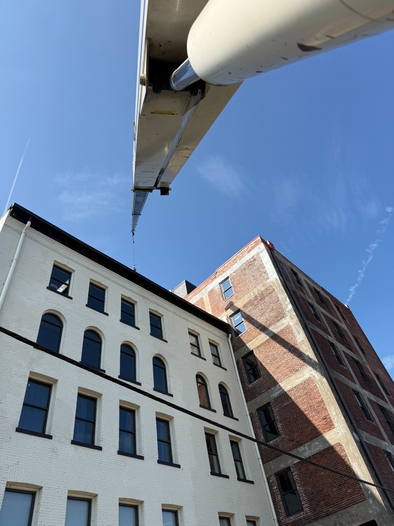 Crane boom working between multistory buildings